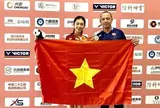 Hai vận động viên Thu Huyền và Hoàng Quy cầm cờ cho Đoàn Thể thao Việt Nam tại Lễ khai mạc Olympic trẻ 2026